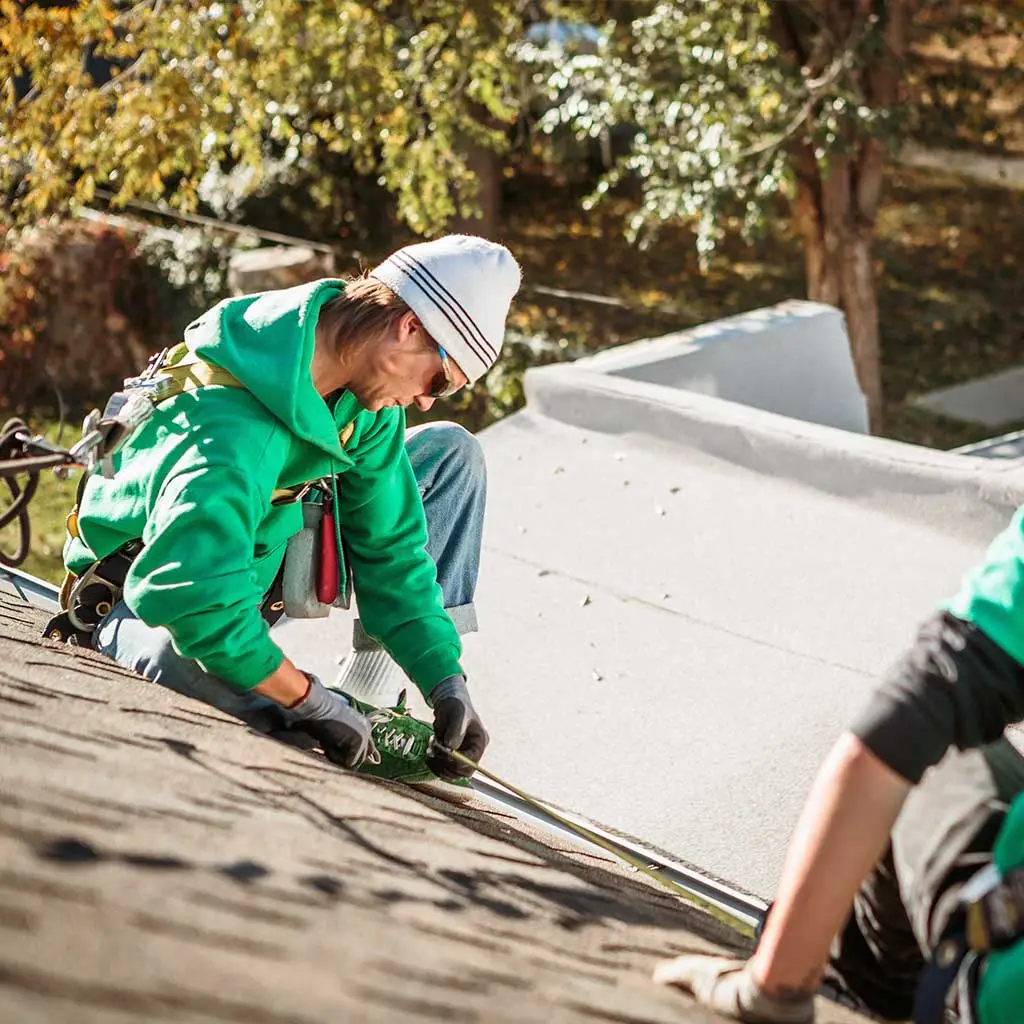 Kuykendall Roofing contractor installing new shingles on a residential roof in Florida during a sunny day