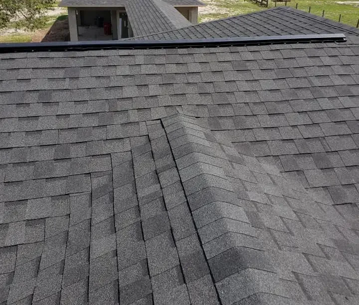 Gray asphalt shingles neatly installed on a residential roof, illustrating a common and affordable roofing option.