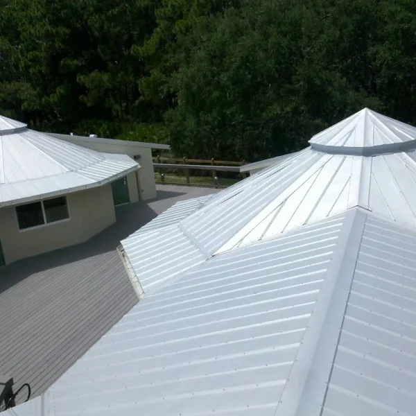 358712392_822837726030710_1187700759863597810_n New white metal roof with a multi-angled structure surrounded by trees, representing high-quality roofing craftsmanship by Kuykendall Roofing, shown alongside FAQ about services