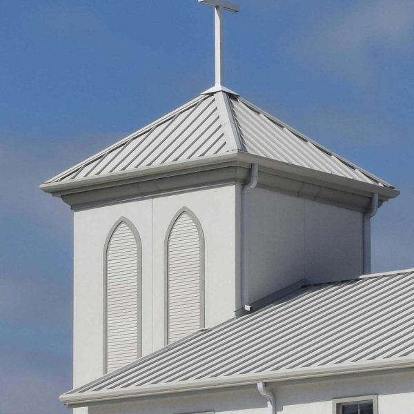 White church with a standing seam metal roof installed by Kuykendall Roofing, representing durable commercial roofing applications